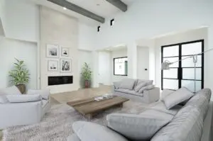 A white living room with three couches and a center table