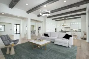 A white living room with couches a gray carpet and a white center table